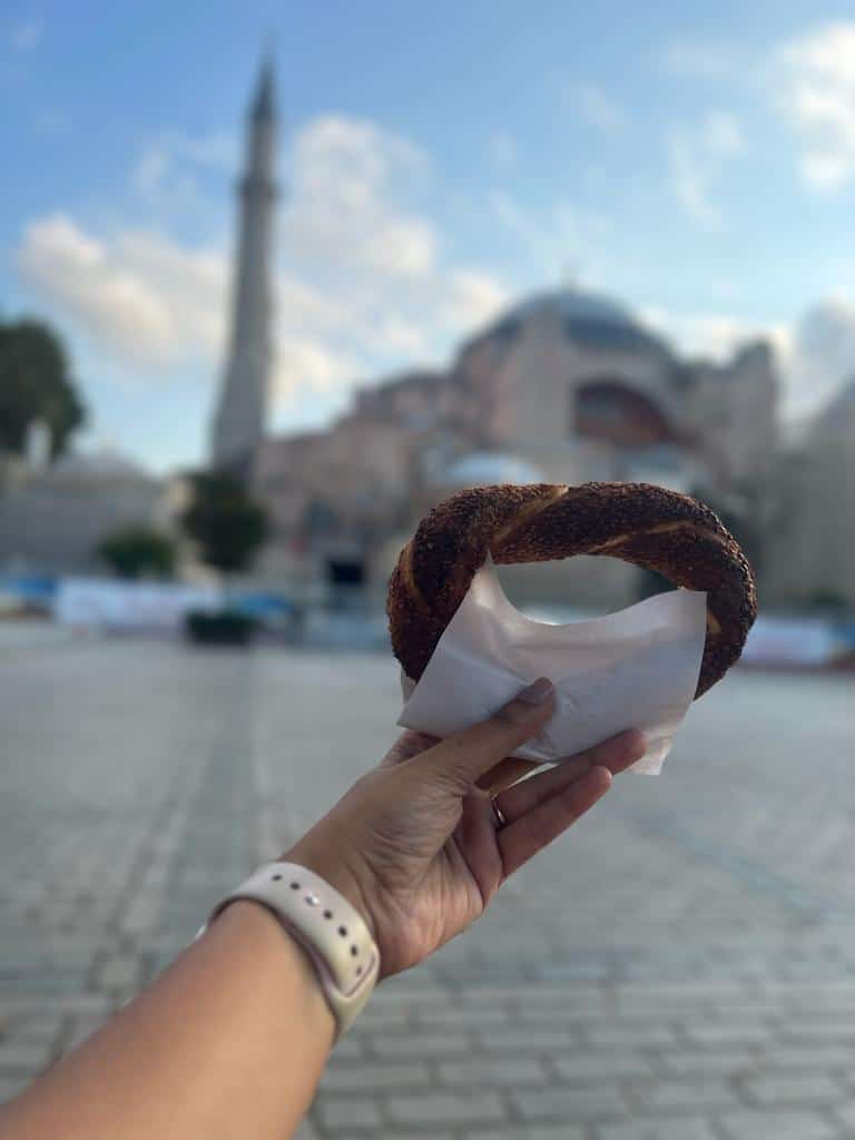 Simit held in hand outside Hagia Sophia - A vegetarian dish in Istanbul