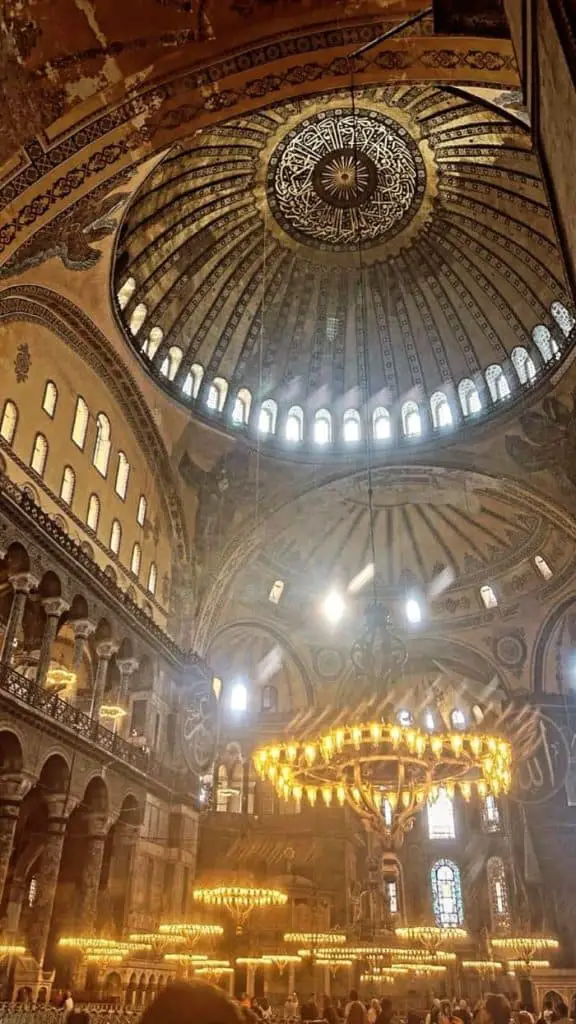 The breathtaking interior dome of the Hagia Sophia, adorned with intricate calligraphy and glowing chandeliers illuminating the historical architecture. A stunning addition to an Istanbul Instagram story.