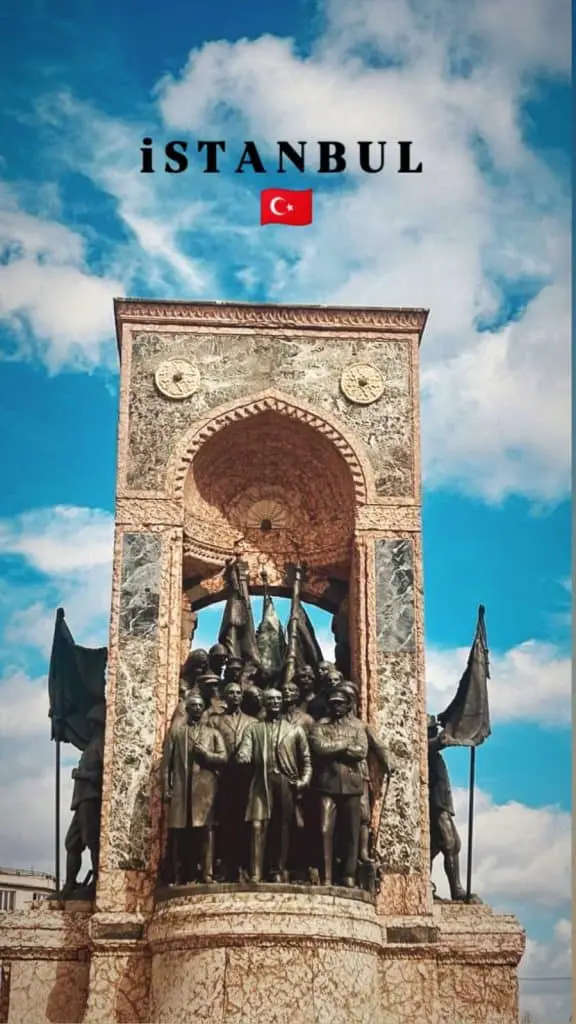  The Republic Monument in Istanbul, a marble and bronze structure featuring prominent Turkish figures, stands tall under a bright blue sky with scattered clouds. The image includes the text "ISTANBUL" with a Turkish flag icon, highlighting the monument as a centerpiece for an "Istanbul Instagram story."