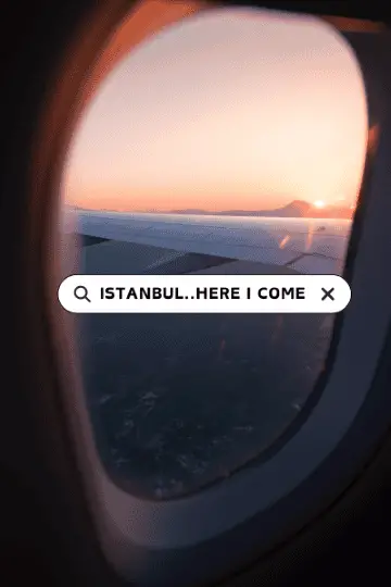  A scenic view from an airplane window showing the wing of the plane and a breathtaking sunset, with the text "Istanbul...Here I Come" displayed in a search bar style overlay.