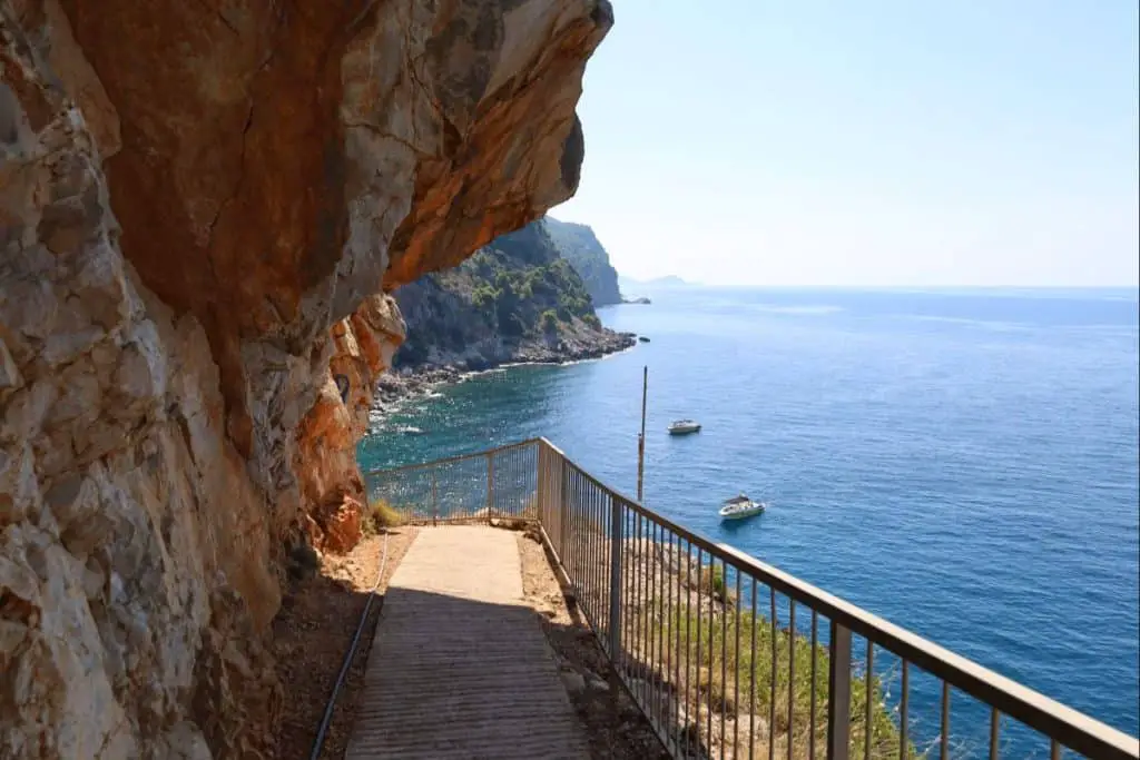 A scenic coastal path leading to the hidden Pasjača Beach, where steep cliffs meet the deep blue sea, offering a private retreat in Croatia travel beaches.