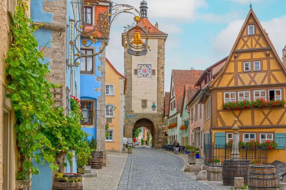 A colorful medieval street in Rothenburg ob der Tauber with half-timbered houses and flower-adorned windows—an enchanting choice for couples seeking fairytale-like honeymoon destinations in Germany