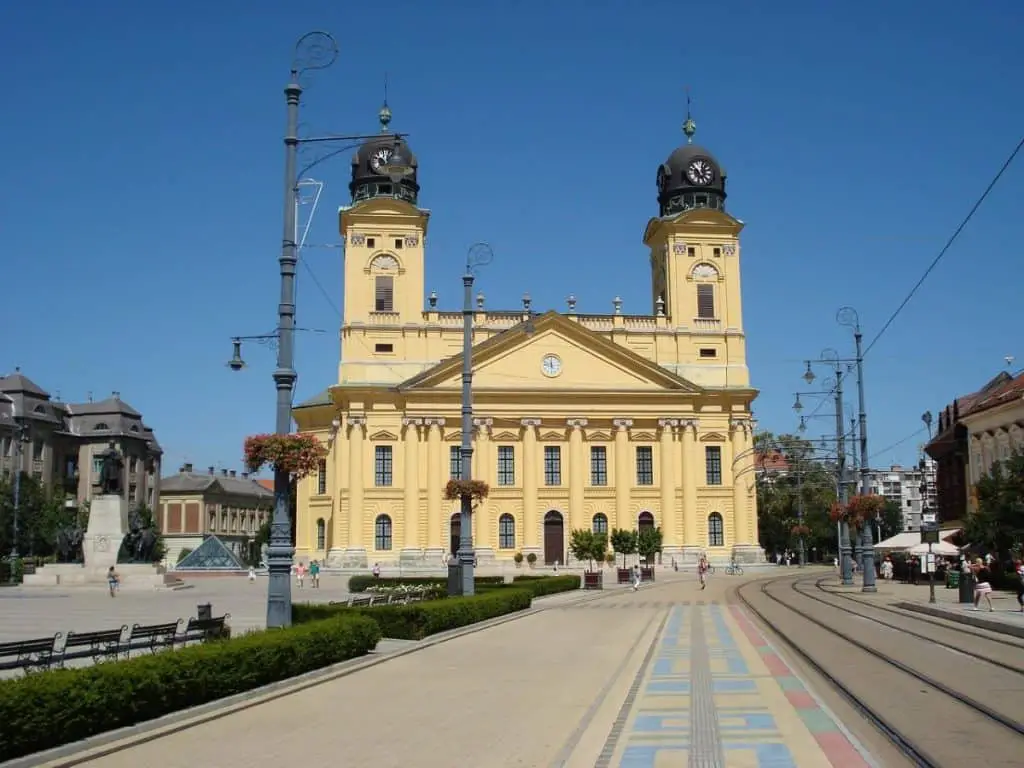 The iconic yellow Great Reformed Church of Debrecen under a clear blue sky, highlighting why this Hungarian city is a fantastic budget-friendly option for Cheap Travel Destinations in Europe Summer.