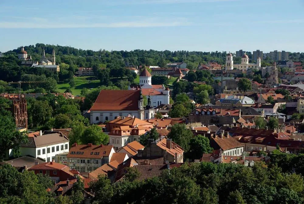 A stunning panoramic view of the city with red-roofed houses and green landscapes, offering an affordable escape for Cheap Travel Destinations in Europe Summer.