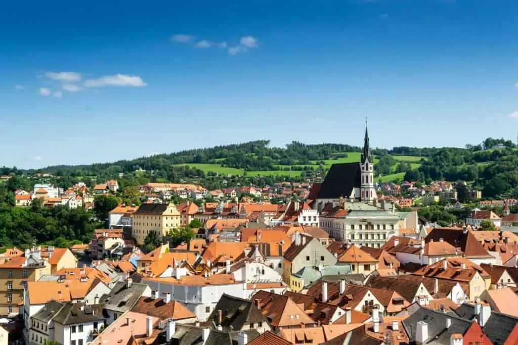  A stunning view of red-roofed houses and a historic church, showcasing why this city is one of the best Cheap Travel Destinations in Europe Summer.